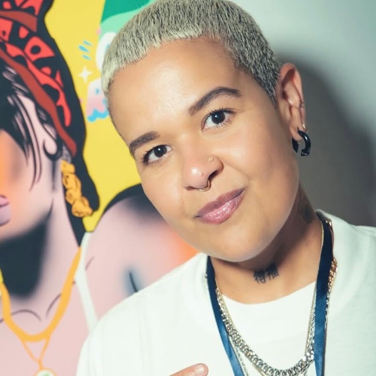 Lisette Correa (Arrrt Addict) throwing a peace sign in front of one of her colourful pop-art murals